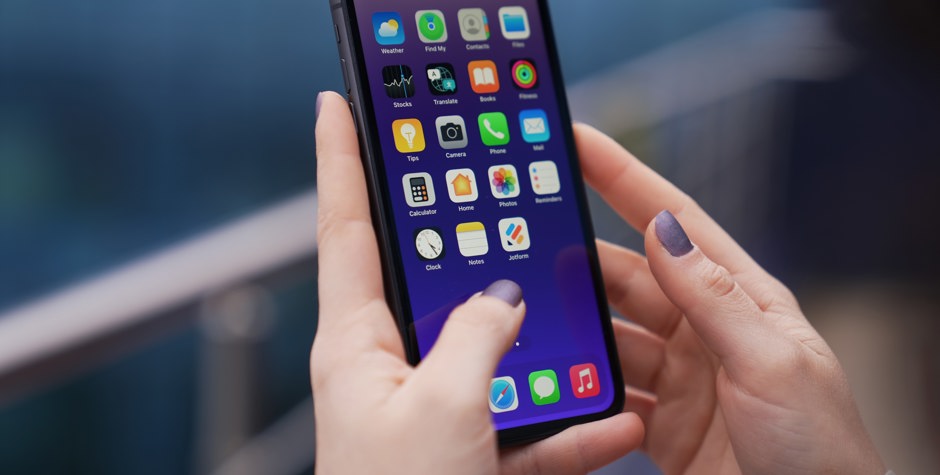 Woman with purple nails using iPhone