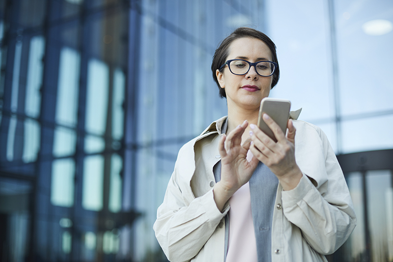 Shutter Stock Lady on Phone in Front of Glass Building